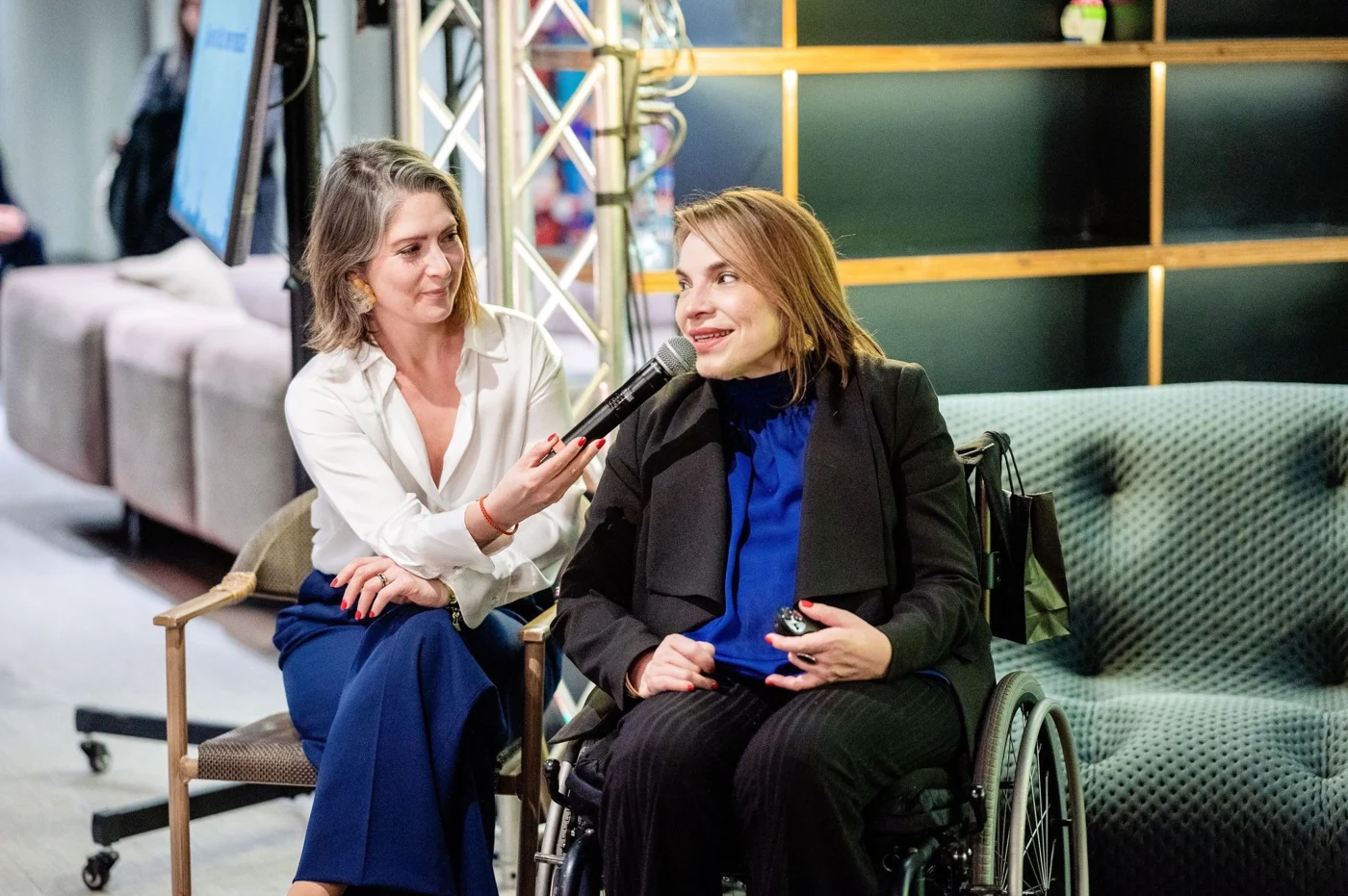 Carolina García Berguecio hablando con micrófono en el encuentro de Revista Nosotras.